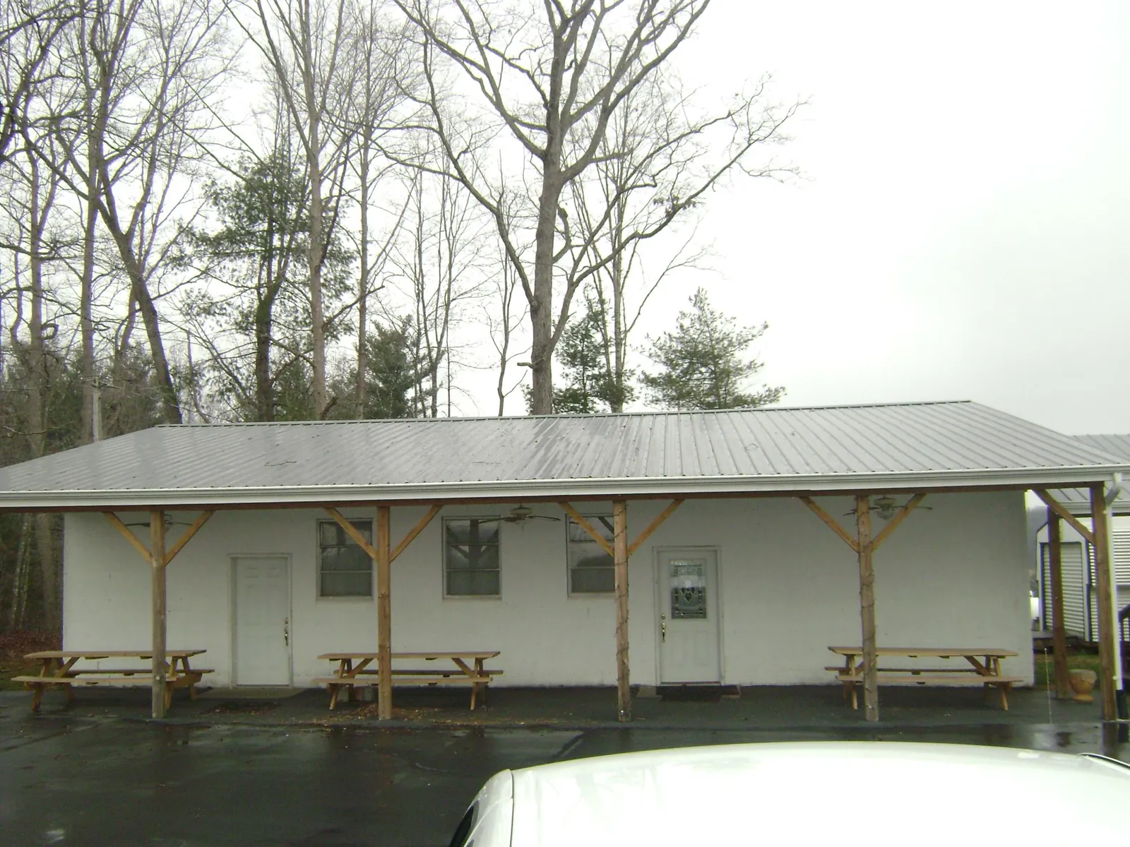 Gray metal roof over a block building with a timber post porch in Popejoy